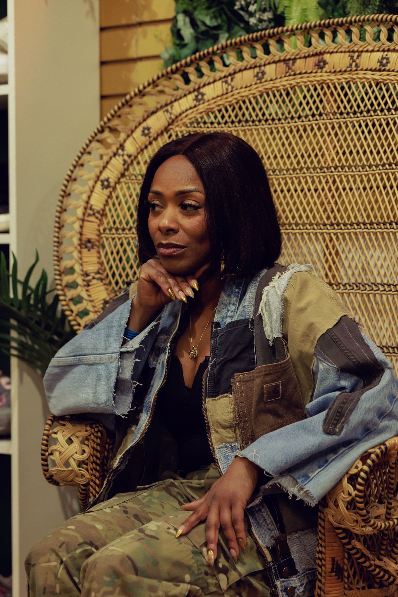 Ingrid Daniel, founder of TRiBE Co, seated in a wicker peacock chair at the shop