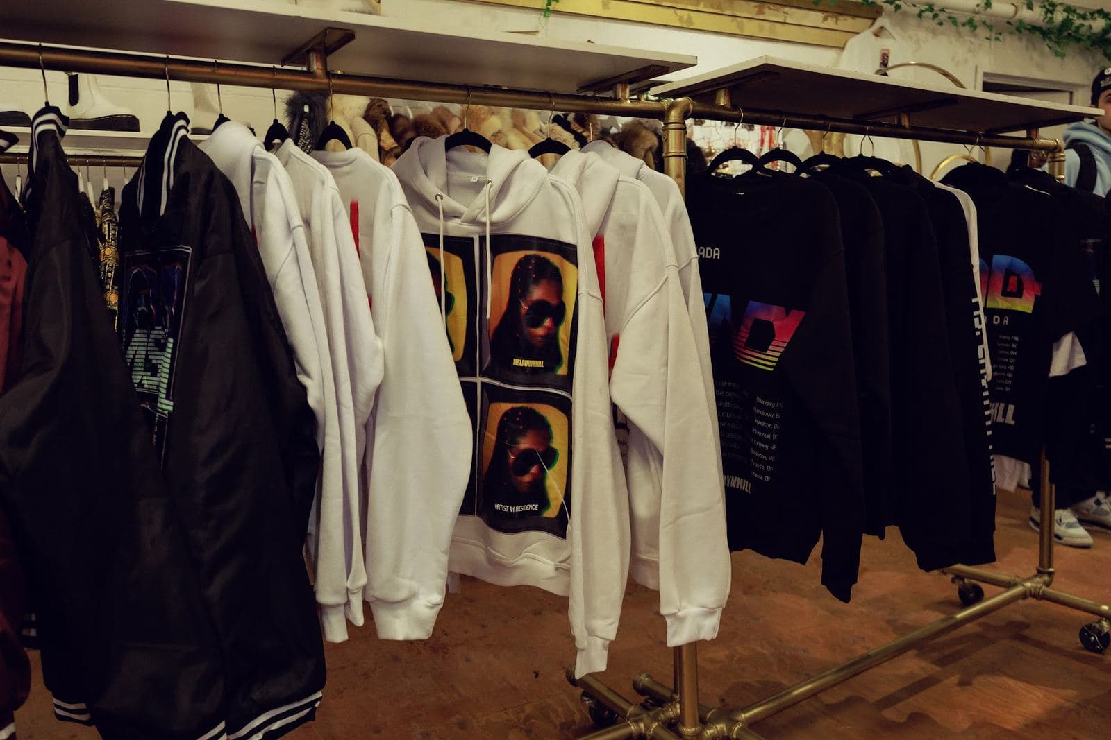 Pop-up hoodies and jackets printed with Ms. Lauryn Hill artwork on a gold rail