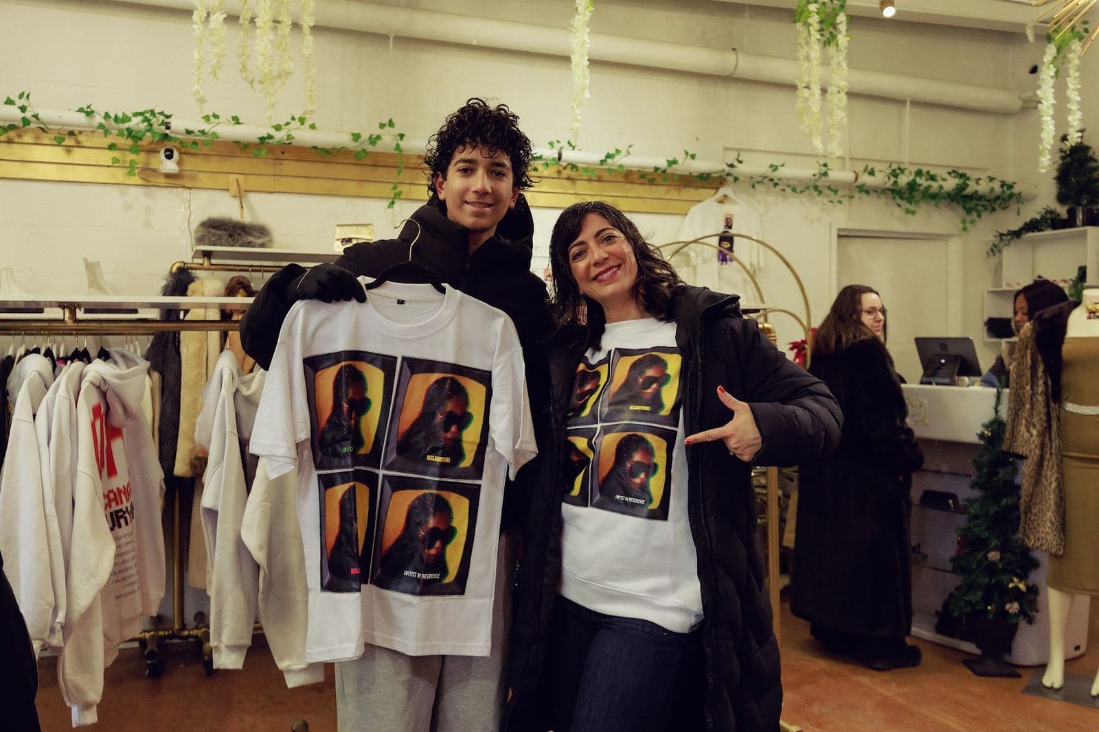 Two guests showing a pop-up tee printed with portraits of Ms. Lauryn Hill